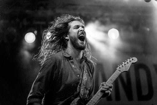 Expressive guitarist passionately performing live on stage in black and white.